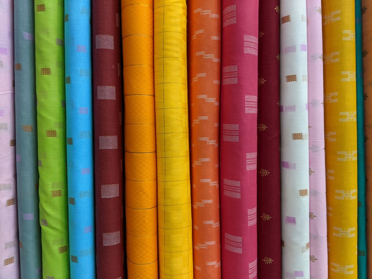 Home A vivid array of assorted fabric rolls showcasing diverse patterns and colors for creative projects.